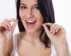 A women using dental floss to clean her teeth
