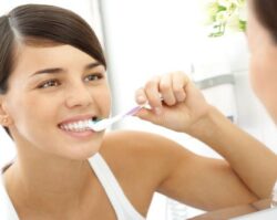 women smiling and brushing teeth